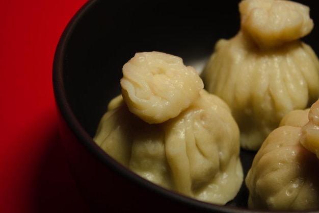 Boulettes cuites à la vapeur traditionnelles khinkali sur le fond rouge