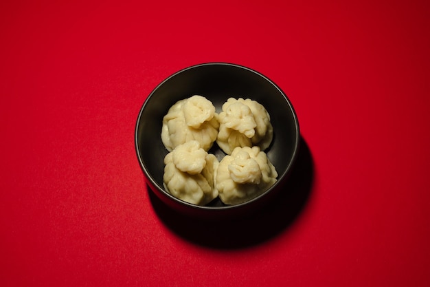 Boulettes cuites à la vapeur traditionnelles khinkali sur le fond rouge