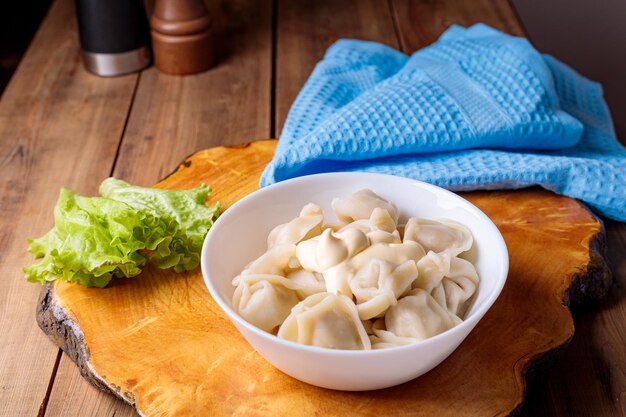 Des boulettes dans une assiette blanche avec de la salade sur un fond en bois