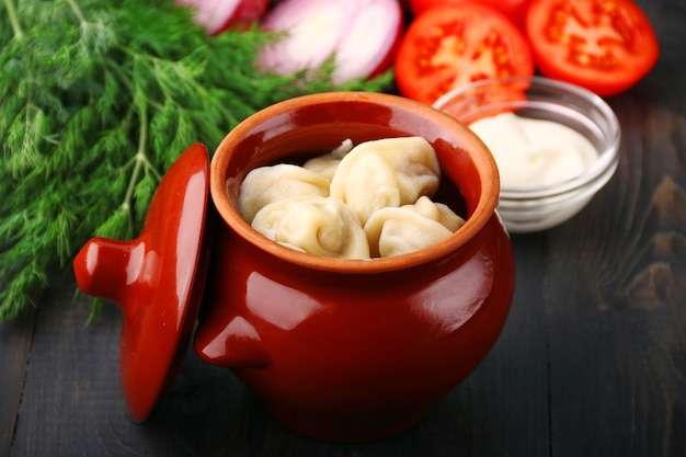 Boulettes dans un pot de légumes et crème sure. Pelmeni russe, boulettes de viande.