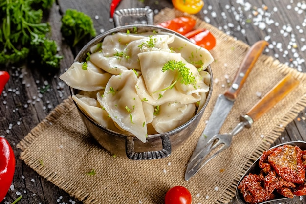 boulettes faites de viande de poisson rouge et blanche, dans une assiette de bol rustique vintage, cuillère couteau fourchette