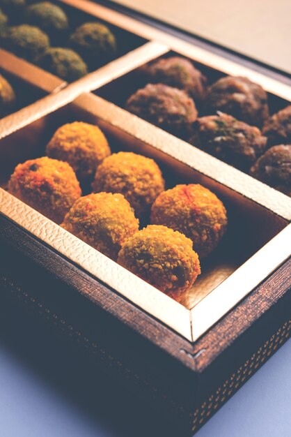 Boulettes de flocons d'avoine aux dattes ou fruits secs Laddu dans une assiette d'emballage de boîte-cadeau, mise au point sélective