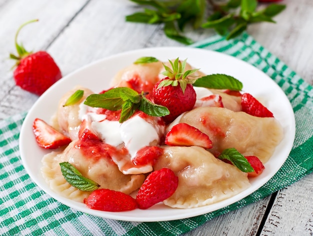 Boulettes fraîches avec des fraises et de la crème aigre