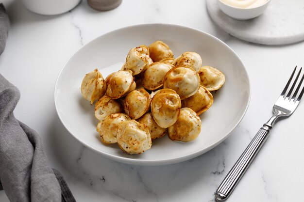 Boulettes frites sur une assiette blanche Plat russe Boulettes Sur une assiette blanche et un fond blanc