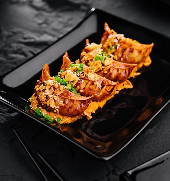 Photo des boulettes frites gyoza sur une assiette noire