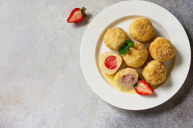 Boulettes de fromage cottage avec des fraises fraîches servies avec de la sauce sourhoney copy space