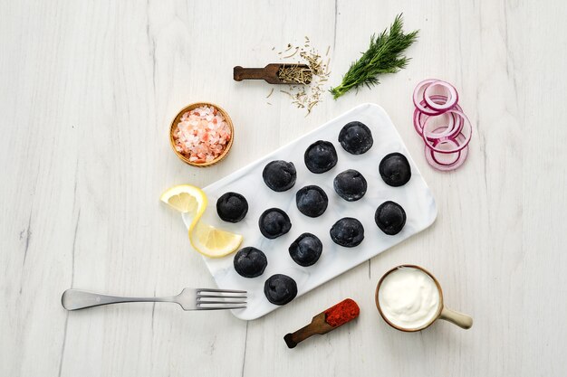 Boulettes noires avec pâte à l'encre de seiche sur plaque de marbre