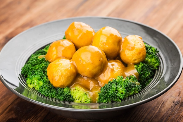 Boulettes de poisson au curry avec du brocoli sur une plaque