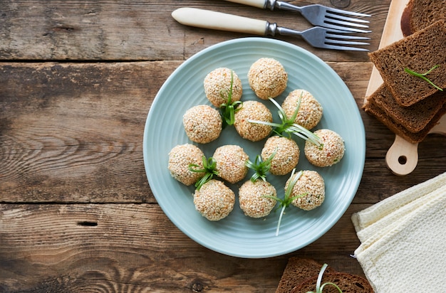 Boulettes de poisson aux légumes et graines de sésame sur une plaque bleue