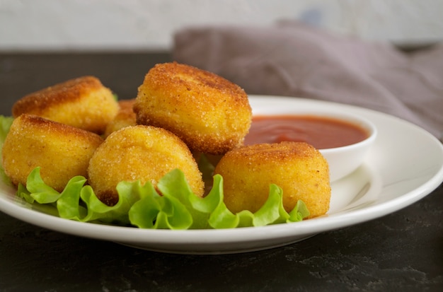 Boulettes de pommes de terre frites panées avec sauce tomate