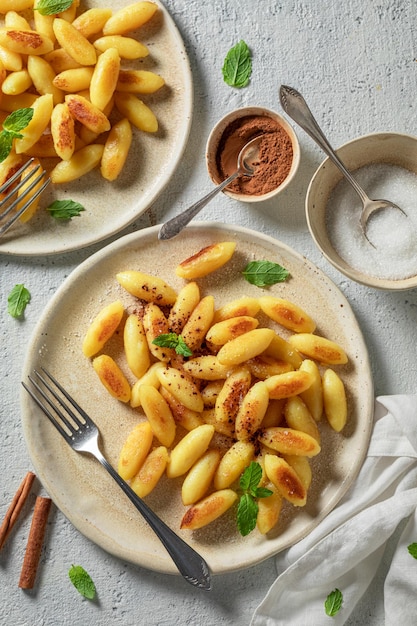 Boulettes de pommes de terre savoureuses et chaudes frites avec du beurre et du sucre