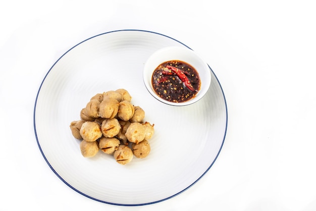 Boulettes de porc grillées avec sauce chili douce dans une assiette blanche sur fond blanc