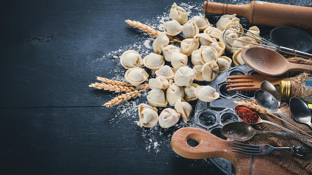 Boulettes de raviolis pelmeni russes traditionnels avec de la viande sur fond de béton noir Vue de dessus Copyspace