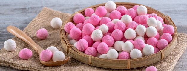 Boulettes de riz gluant tangyuan rouge et blanc cru sur table en bois