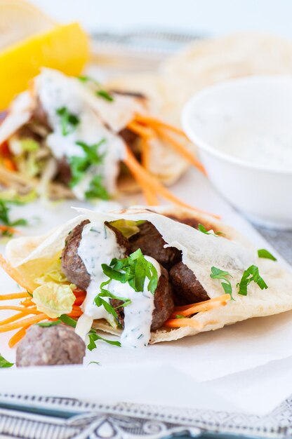 Boulettes de viande d'agneau maison dans un pain plat pita avec sauce au yaourt épicée Gros plan