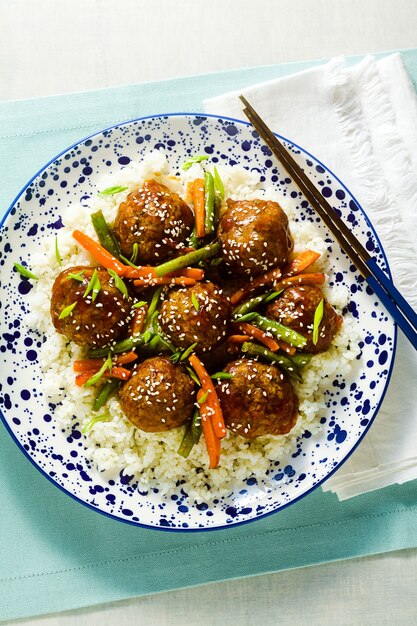 Boulettes de viande asiatiques végétaliennes sans viande en sauce aigre-douce avec riz et légumes cuits. déjeuner équilibré ou dîner sain. l'alimentation de rue