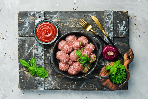 Boulettes de viande de boeuf cru frais avec des épices dans une casserole Vue de dessus Sur un fond de pierre