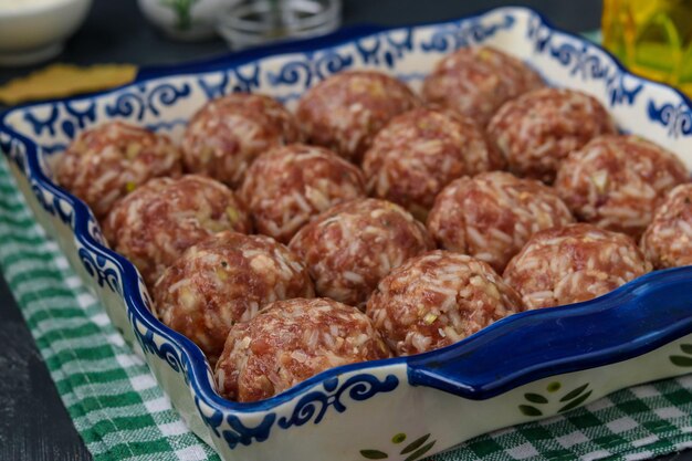 Photo les boulettes de viande crues avec du riz cuisent sous forme de céramique, orientation horizontale, gros plan