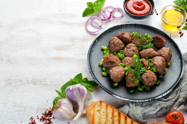 Boulettes de viande cuites au four avec des oignons sur une plaque noire Vue de dessus Espace de copie gratuit