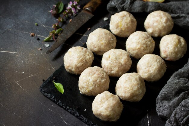 Boulettes de viande de dinde maison crues sur tableau noir en ardoise Espace libre pour votre texte