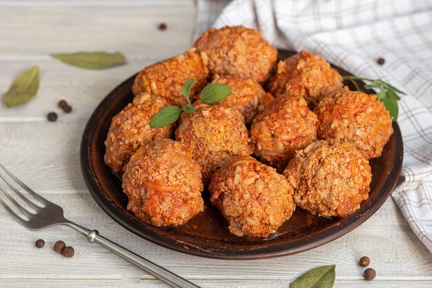 Boulettes de viande sur fond clair avec des feuilles de sauge et de persil. Déjeuner fait maison.