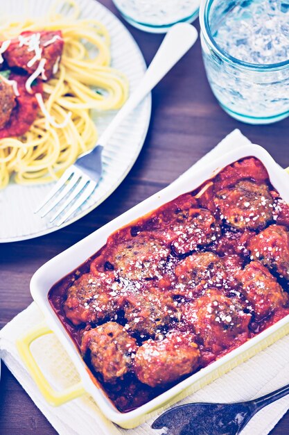 Boulettes de viande italiennes faites maison garnies de coriandre et de parmesan sur des spaghettis pour le dîner.