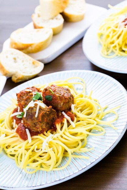 Boulettes de viande italiennes faites maison garnies de coriandre et de parmesan sur des spaghettis pour le dîner.