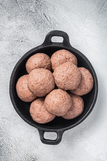 Boulettes de viande de légumes crus sans viande dans une poêle Fond blanc Vue de dessus