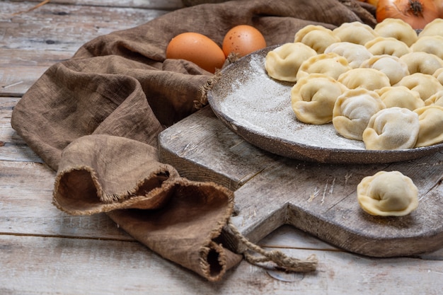 Boulettes de viande non cuite - pelmeni russe sur une planche à découper