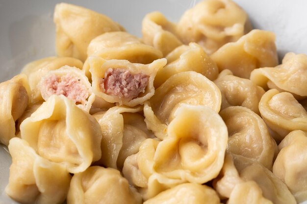 Boulettes de viande pelmeni russe fait maison dans un bol isolé sur fond clair avec un tracé de détourage