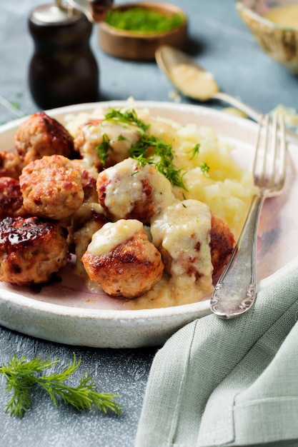 Photo boulettes de viande avec purée de pommes de terre, aneth et sauce à la crème sur une pierre grise serrée ou du béton