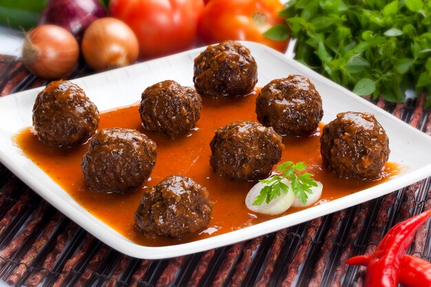 Photo boulettes de viande à la sauce tomate dans une assiette blanche.