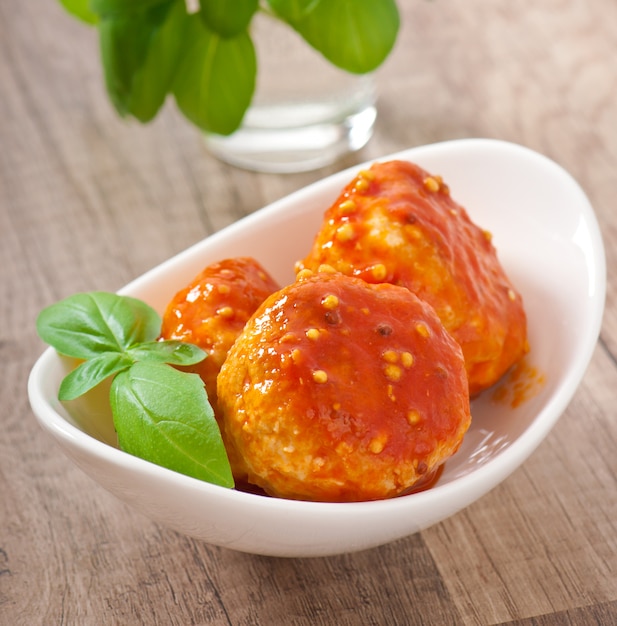 boulettes de viande à la sauce tomate, décorées de feuilles de basilic