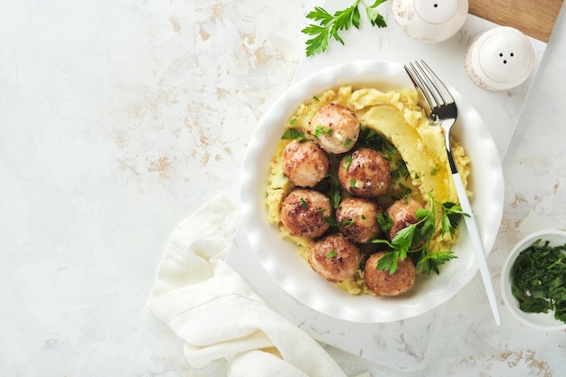 Boulettes de viande suédoises en sauce à la crème pommes de terre et sauce aux airelles dans un bol sur fond d'ardoise ou de béton Cuisine suédoise Délicieuse purée de pommes de terre crémeuse Vue de dessus