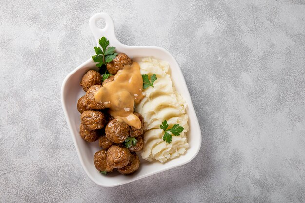 boulettes de viande suédoises traditionnelles avec sauce crémeuse et purée de pommes de terre sur fond gris