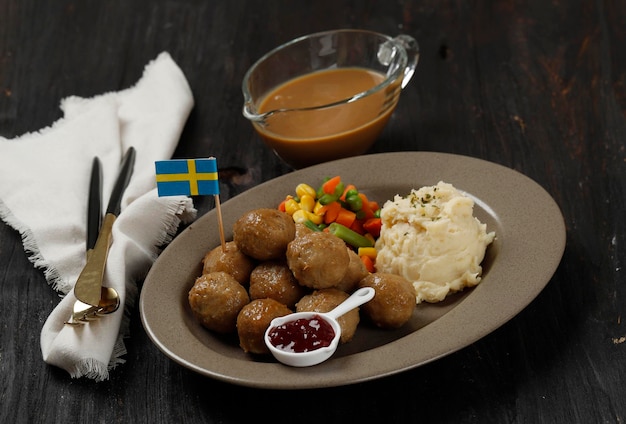 Boulettes de viande traditionnelles suédoises avec purée de pommes de terre et sauce aux canneberges Concept de cuisine suédoise sur table en bois