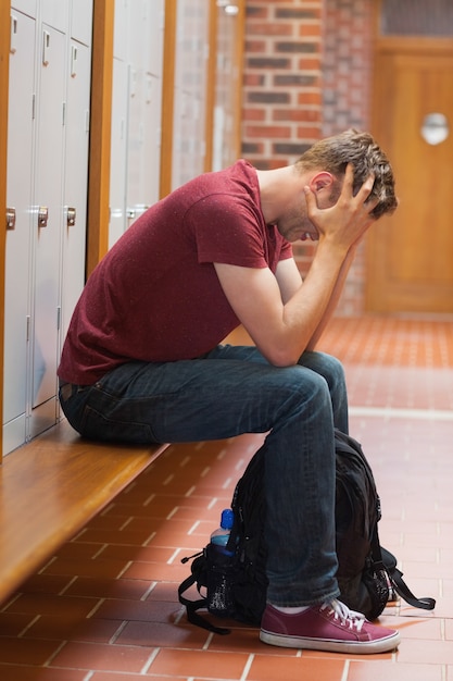 Bouleversé bel étudiant tenant sa tête