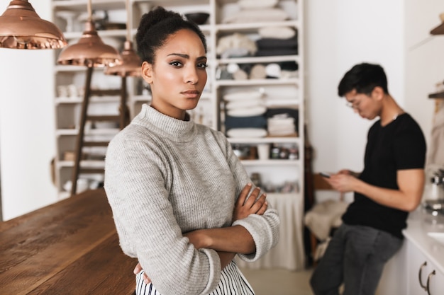 Bouleversé femme afro-américaine tenant les mains ensemble tristement