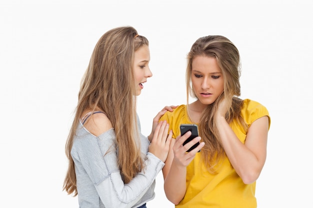 Bouleversé la jeune femme tenant son téléphone cellulaire par son ami