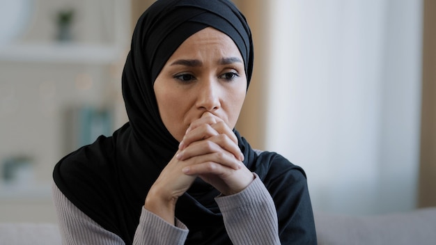 Bouleversée fille triste en hijab s'asseoir seule recevoir de mauvaises nouvelles se sentir déprimée frustrée femme musulmane inquiète