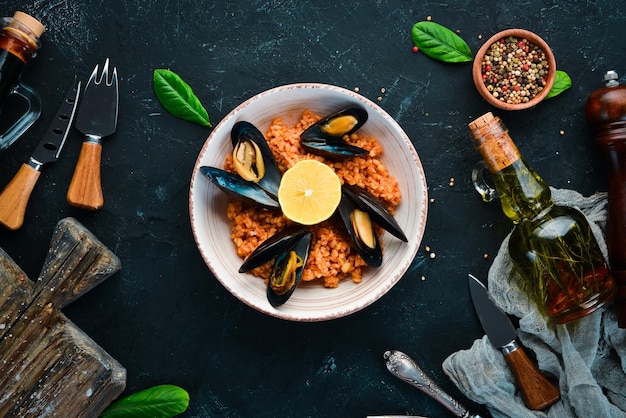 Boulgour aux moules et sauce tomate dans une assiette Sur le vieux fond Vue de dessus Espace libre pour votre texte