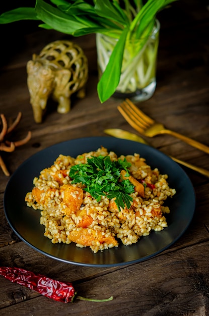 Boulgour à la citrouille sur une table en bois. Recettes végétariennes de la cuisine indienne.