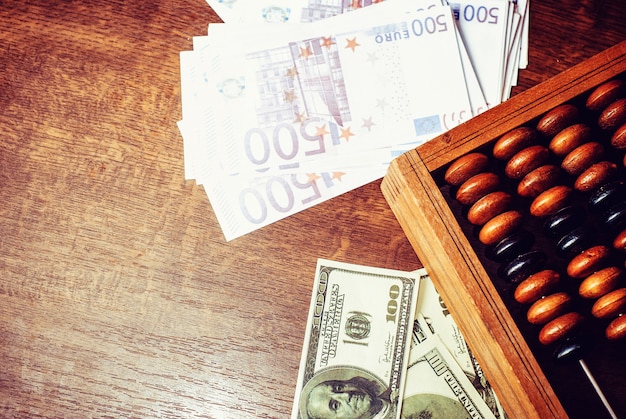 Boulier antique avec dollar américain et euro sur fond de table en bois ancien