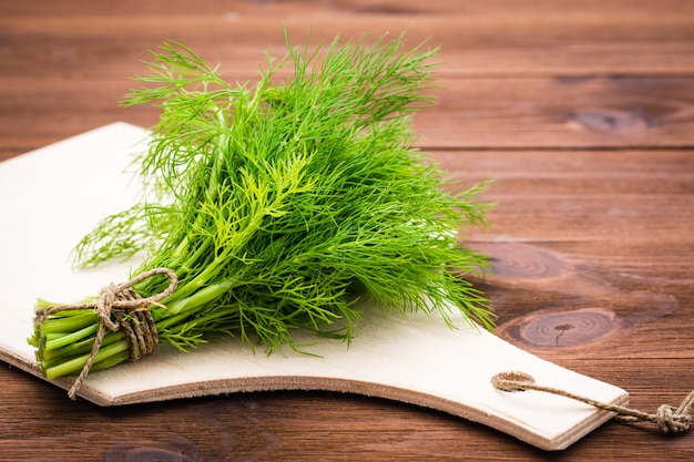 Bouquet d'aneth frais sur une planche à découper sur la table