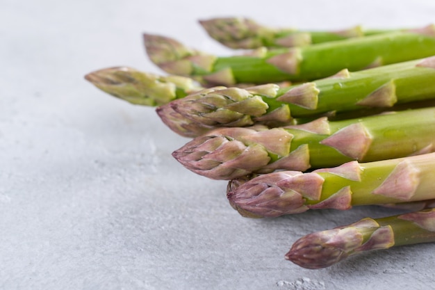 Bouquet d'asperges fraîches crues sur un fond de béton gris