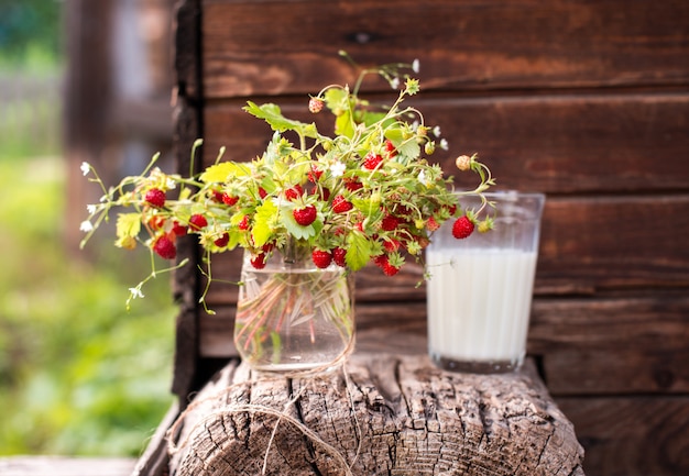 Bouquet de baies dans un verre sur un mur en bois