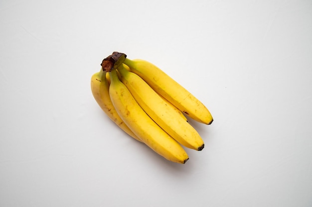 Bouquet de bananes fraîches et mûres sur fond blanc