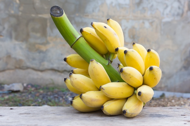 Photo bouquet de bananes mûres sur le vieux mur