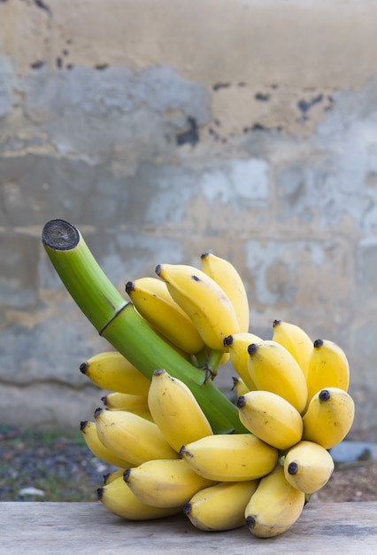 Bouquet de bananes mûres sur le vieux mur