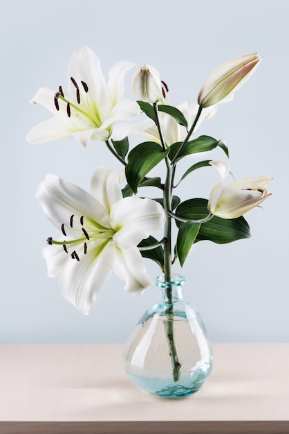 Bouquet de beaux lys blancs dans un vase sur la table.